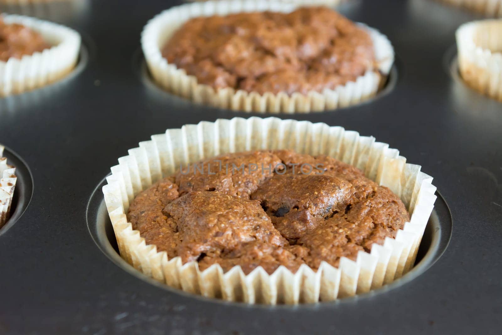 Just baked sweet chocolate cupcakes still in bake tray.