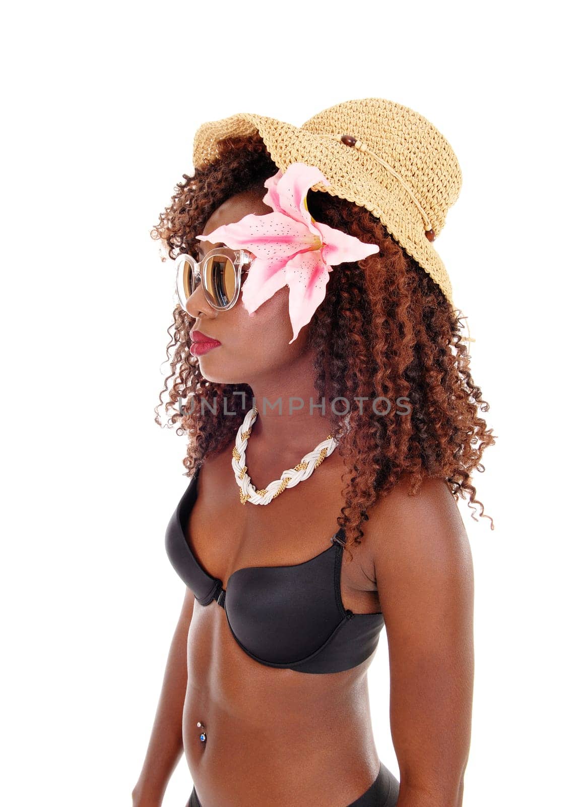 A lovely young African American woman in a black bra and straw hat.standing in profile isolated for white background..