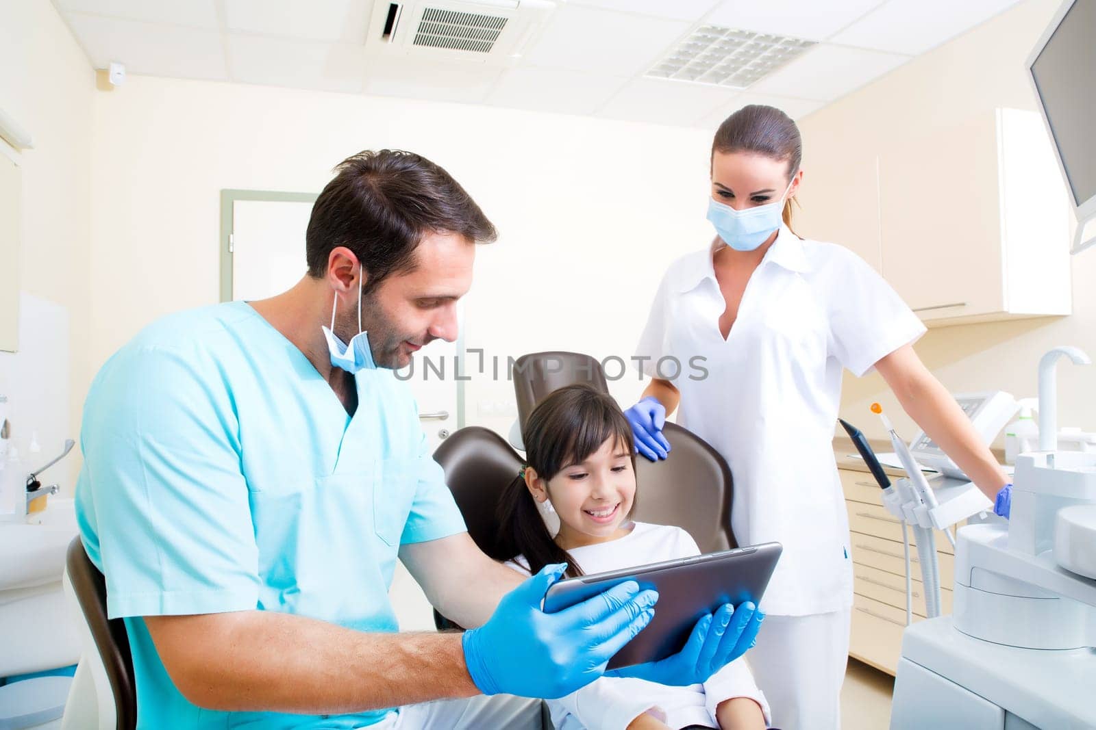 A little girl at the dentist getting a explanation with a Tablet PC..