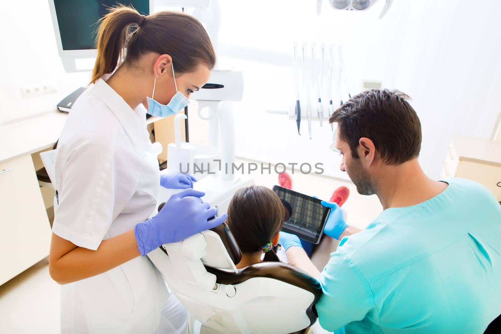 A little girl at the dentist getting a explanation with a Tablet PC..