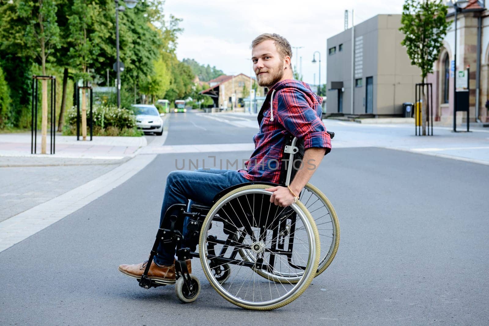 young disabled man in wheelchair on road