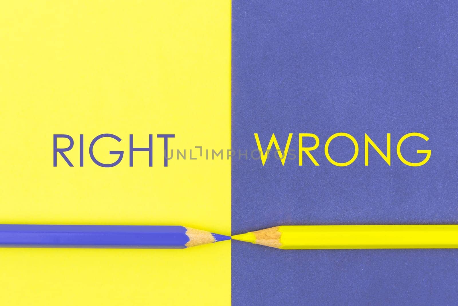 Right versus Wrong contrast concept . Yellow and Violet coloured pencils and paper.