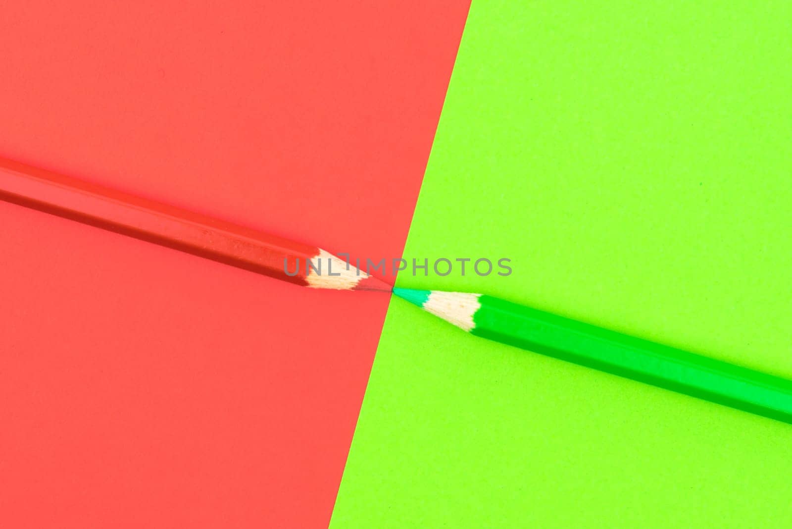 Green and Red coloured pencils and paper, abstract contrast conceptual image