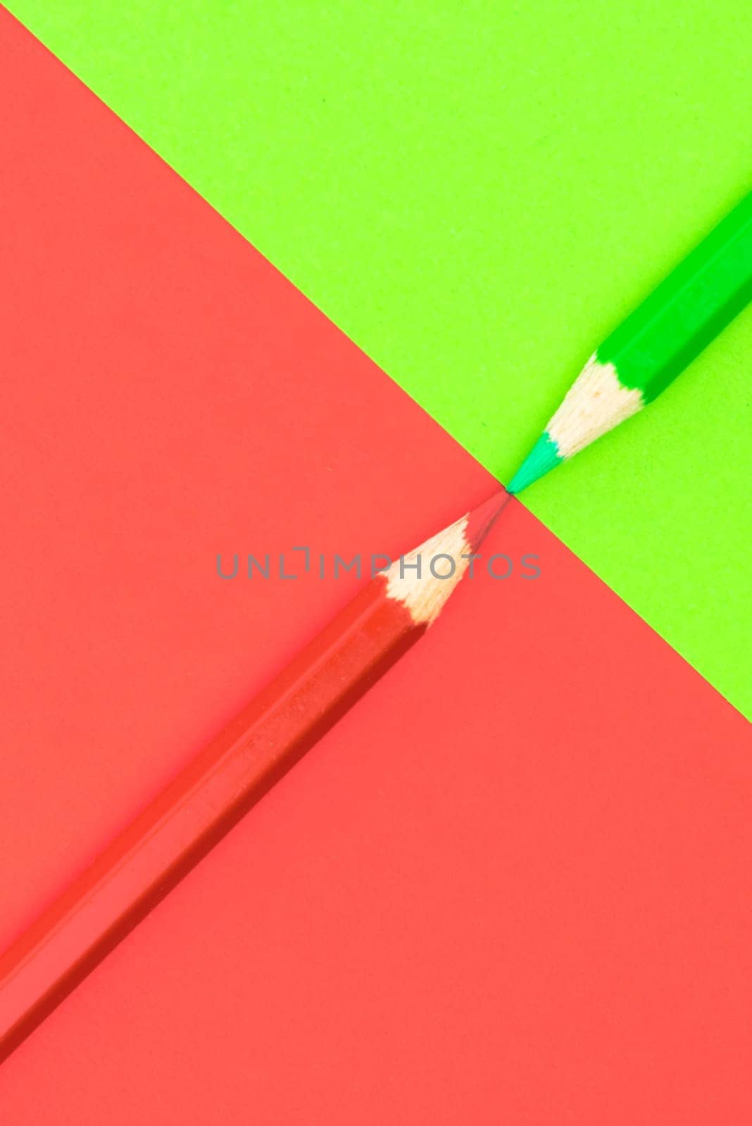 Green and Red coloured pencils and paper, abstract contrast conceptual image