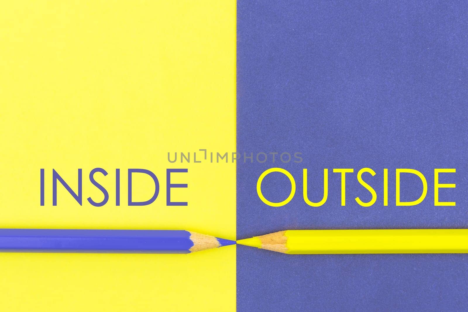 Inside versus Outside contrast concept . Yellow and Violet coloured pencils and paper.
