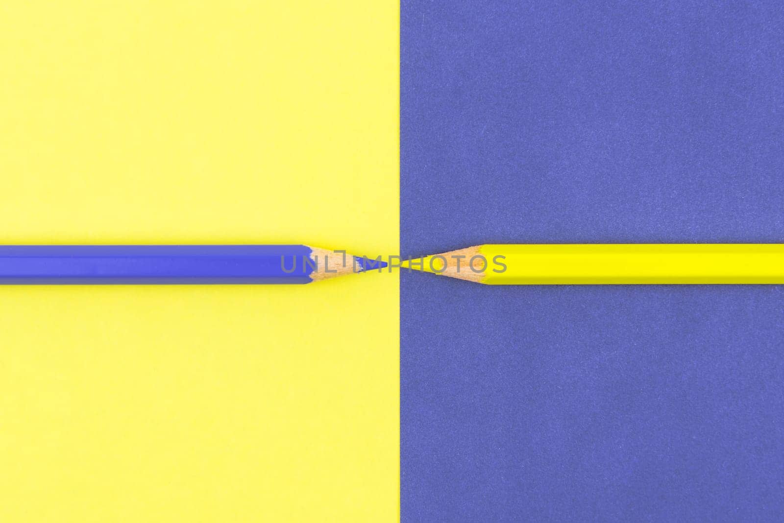 Yellow and Violet coloured pencils and paper, abstract contrast conceptual image