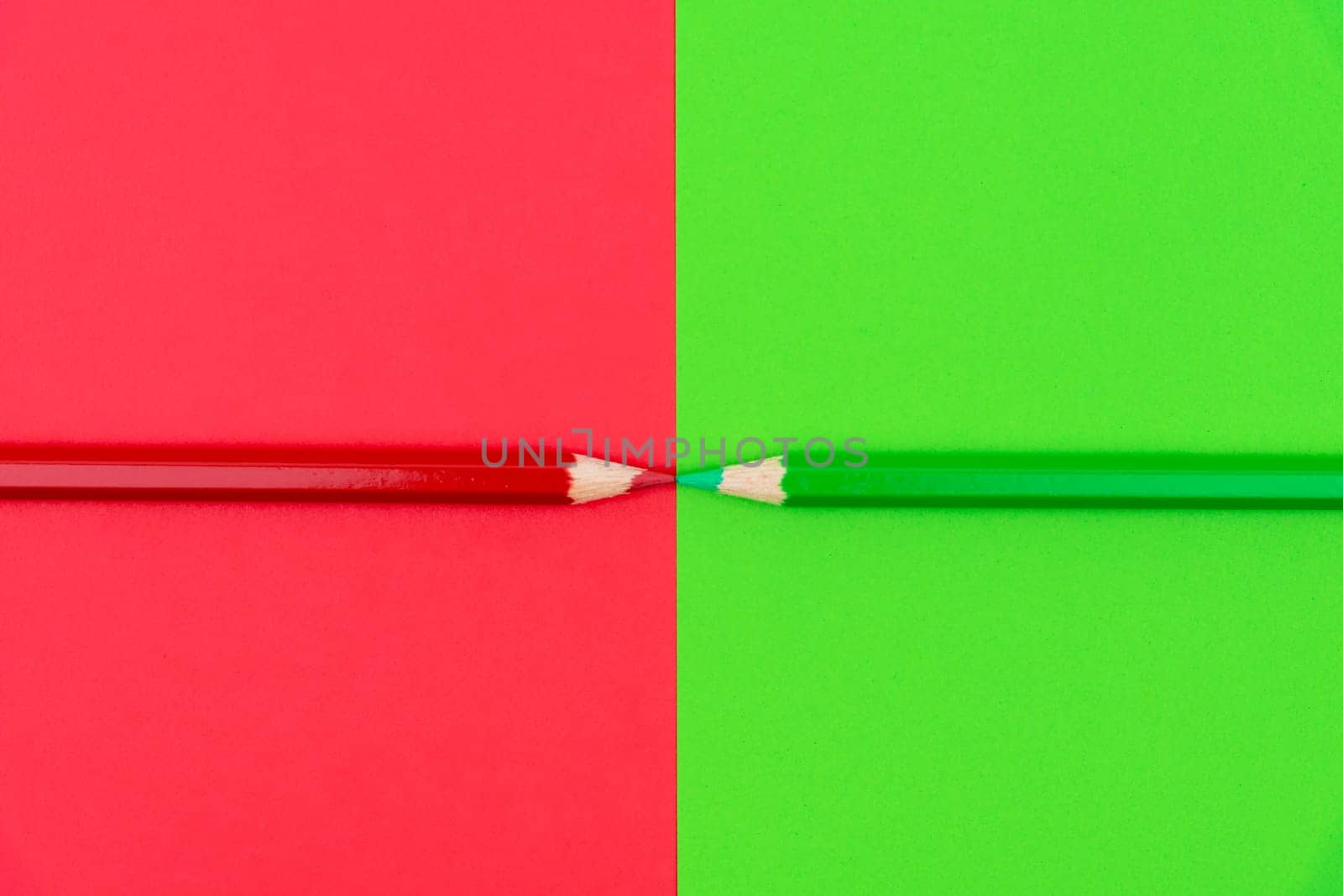 Green and Red coloured pencils and paper, abstract contrast conceptual image