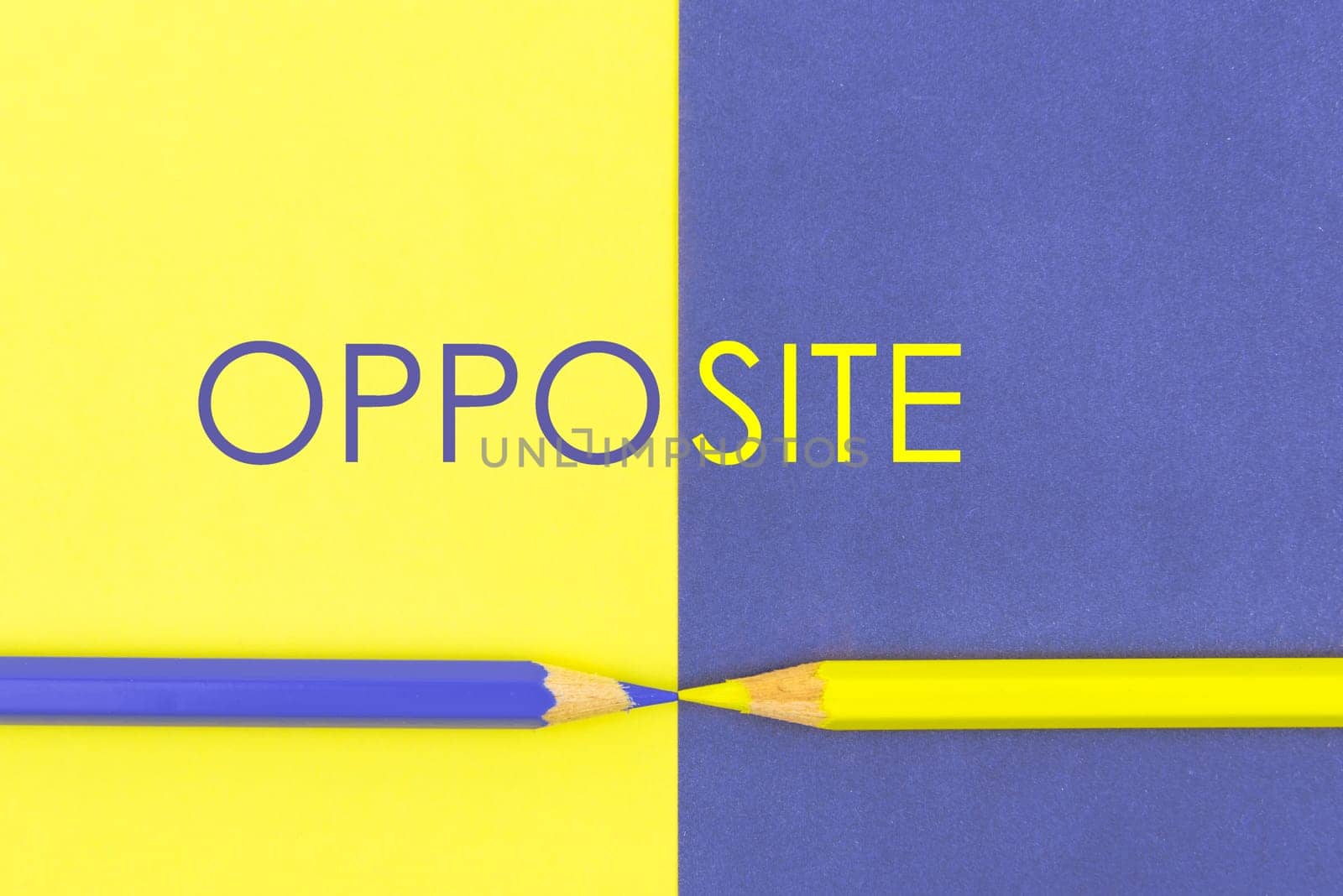 Word OPPOSITE. Yellow and Violet coloured pencils and paper, abstract contrast conceptual image