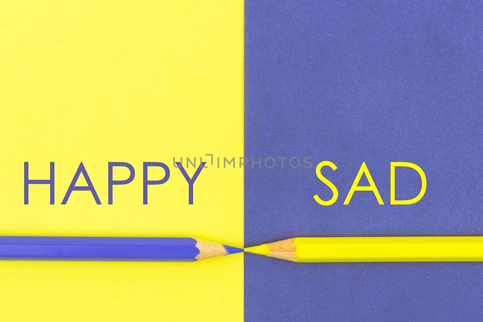 Happy versus Sad contrast concept. Yellow and Violet coloured pencils and paper.