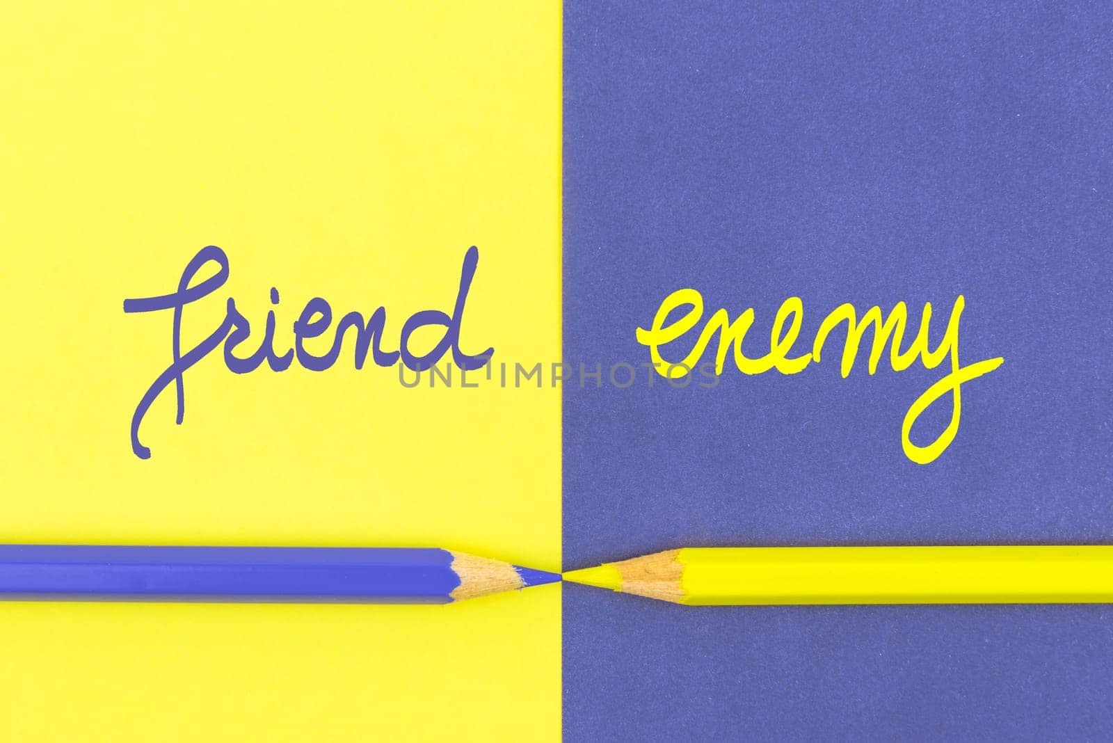Friend versus Enemy contrast concept . Yellow and Violet coloured pencils and paper.