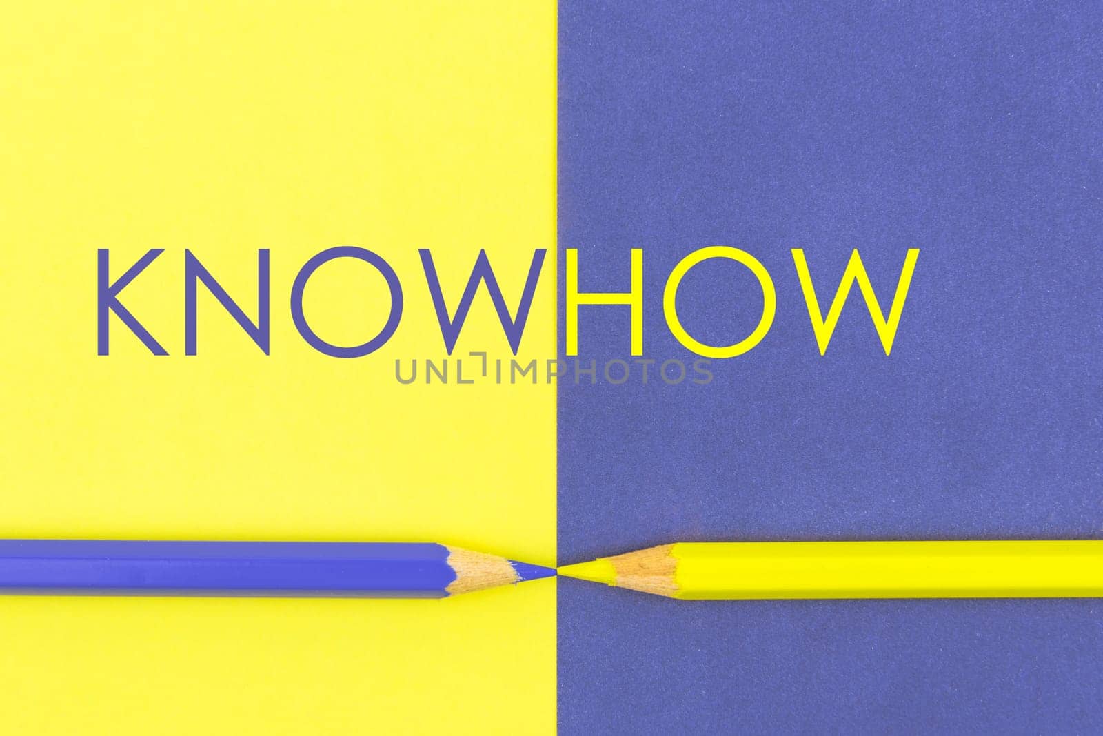 KnowHow concept with Yellow and Violet coloured pencils and paper.