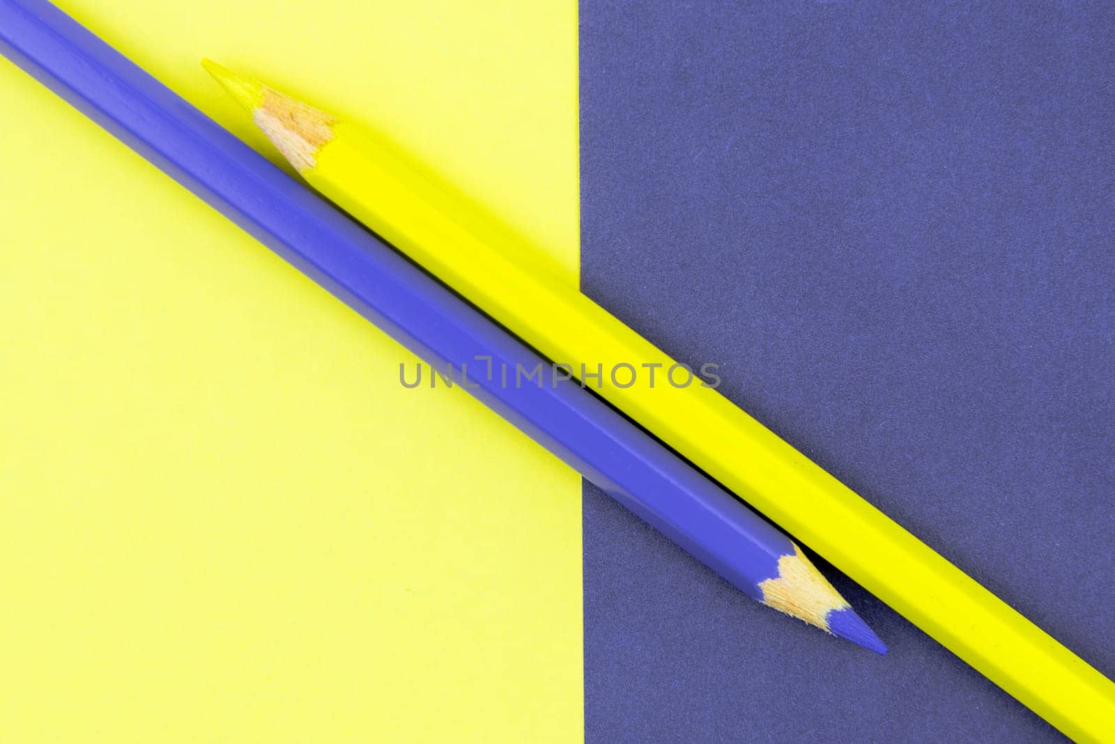 Yellow and Violet coloured pencils and paper, abstract contrast conceptual image