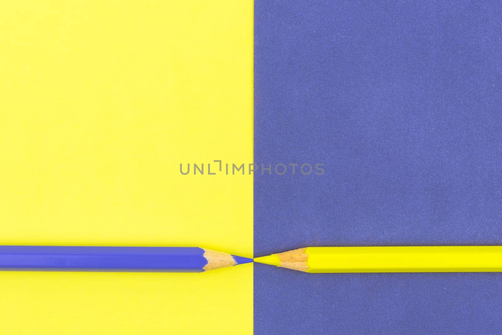 Yellow and Violet coloured pencils and paper, abstract contrast conceptual image