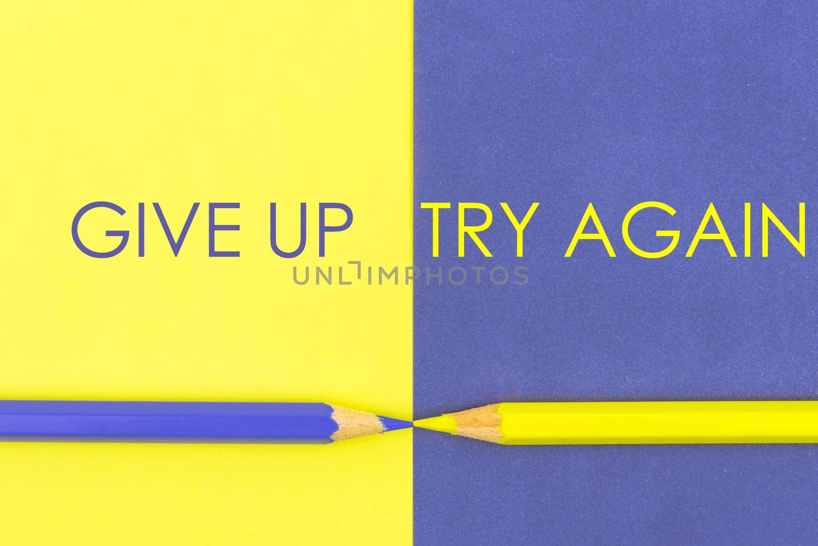 Give Up versus Try Again contrast concept . Yellow and Violet coloured pencils and paper.