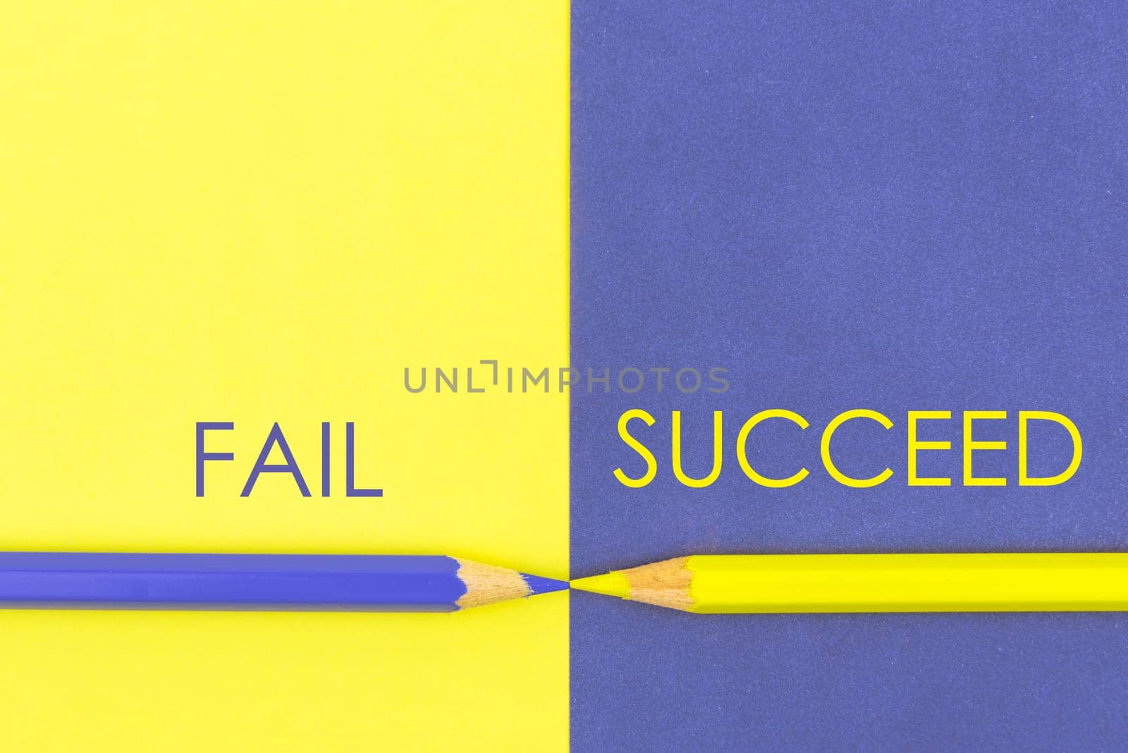 Fail versus Succeed contrast concept . Yellow and Violet coloured pencils and paper.