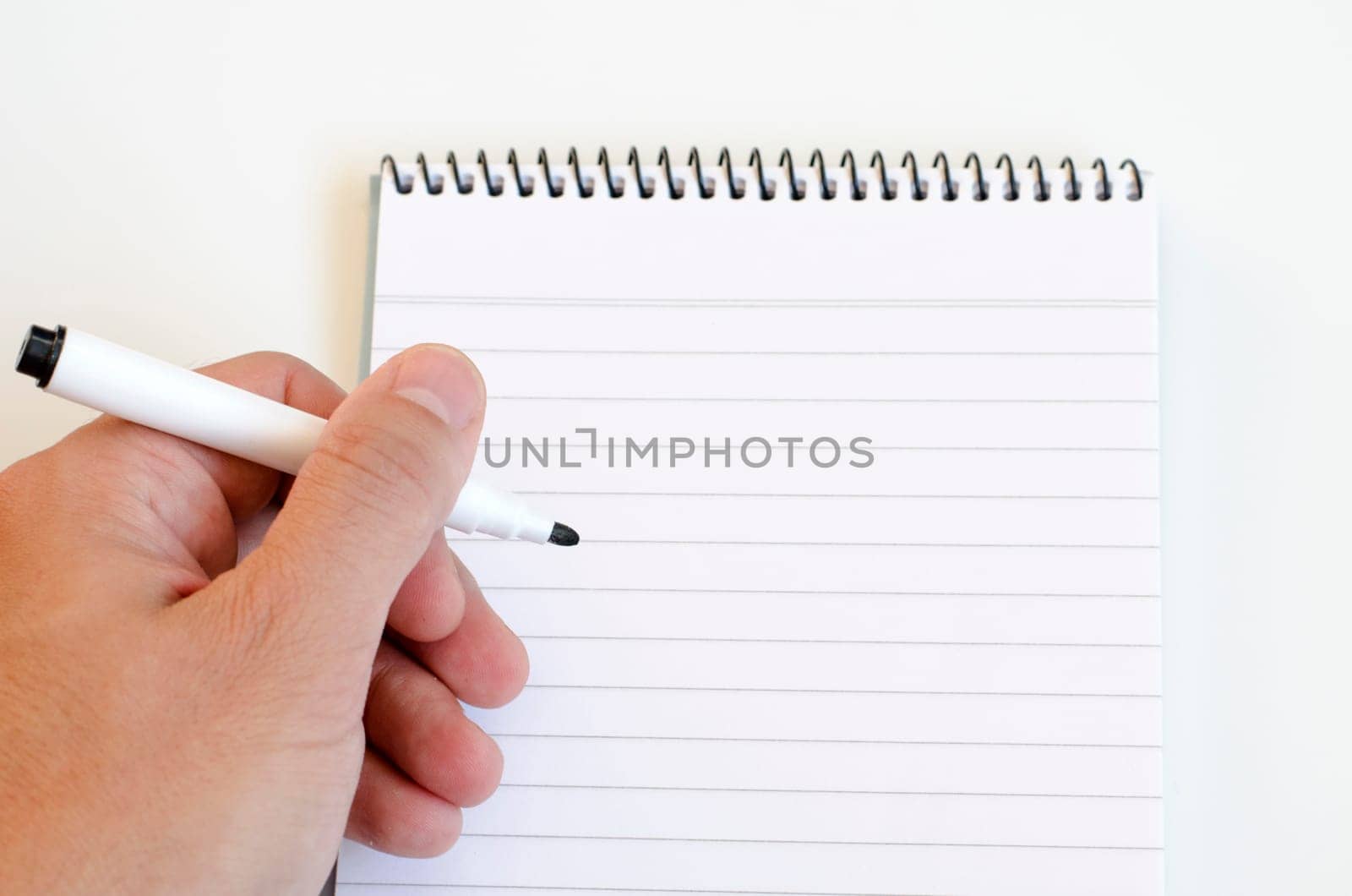 Human hand and notepad over white background