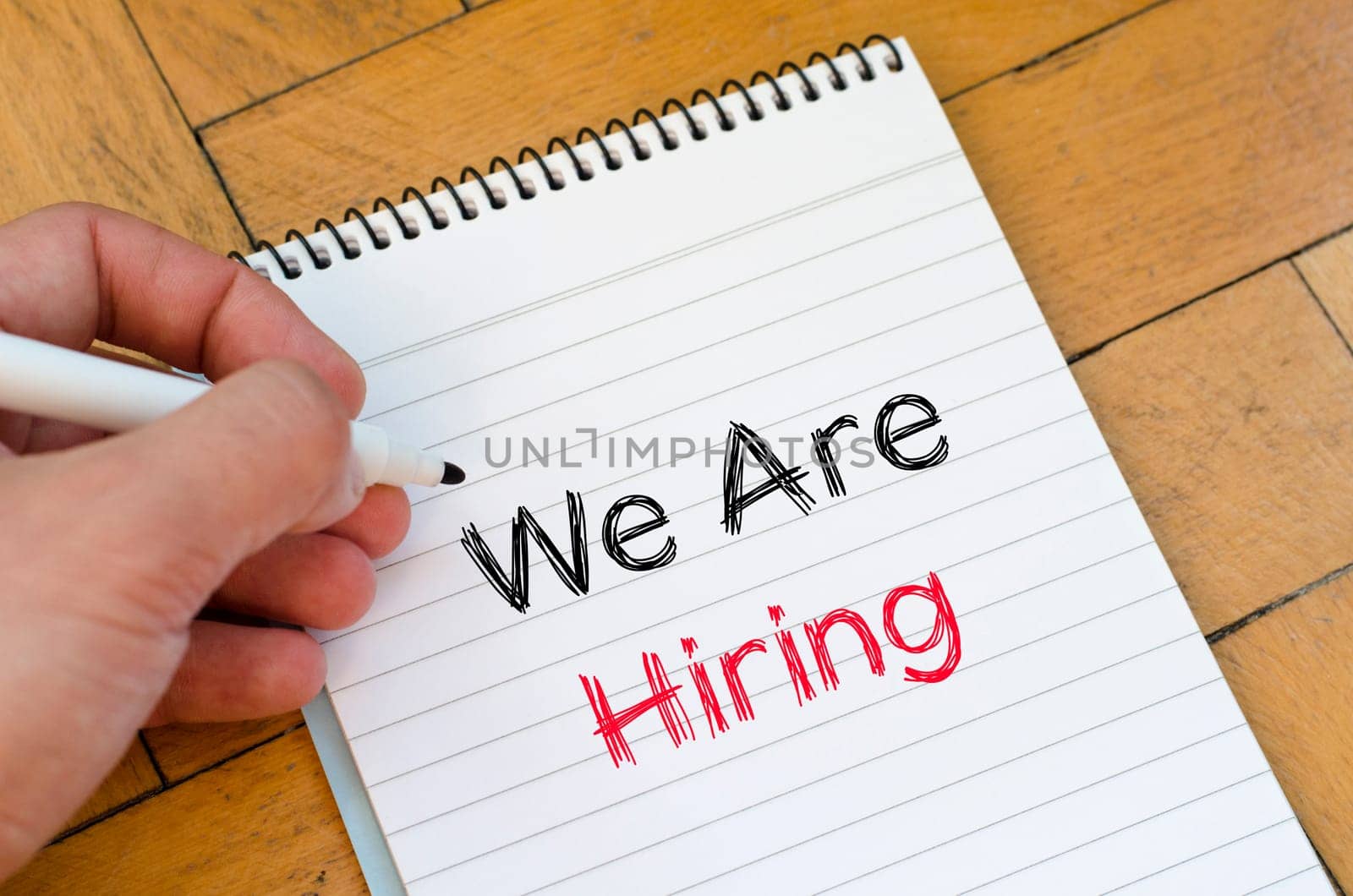 We are hiring text concept on notebook over wooden background