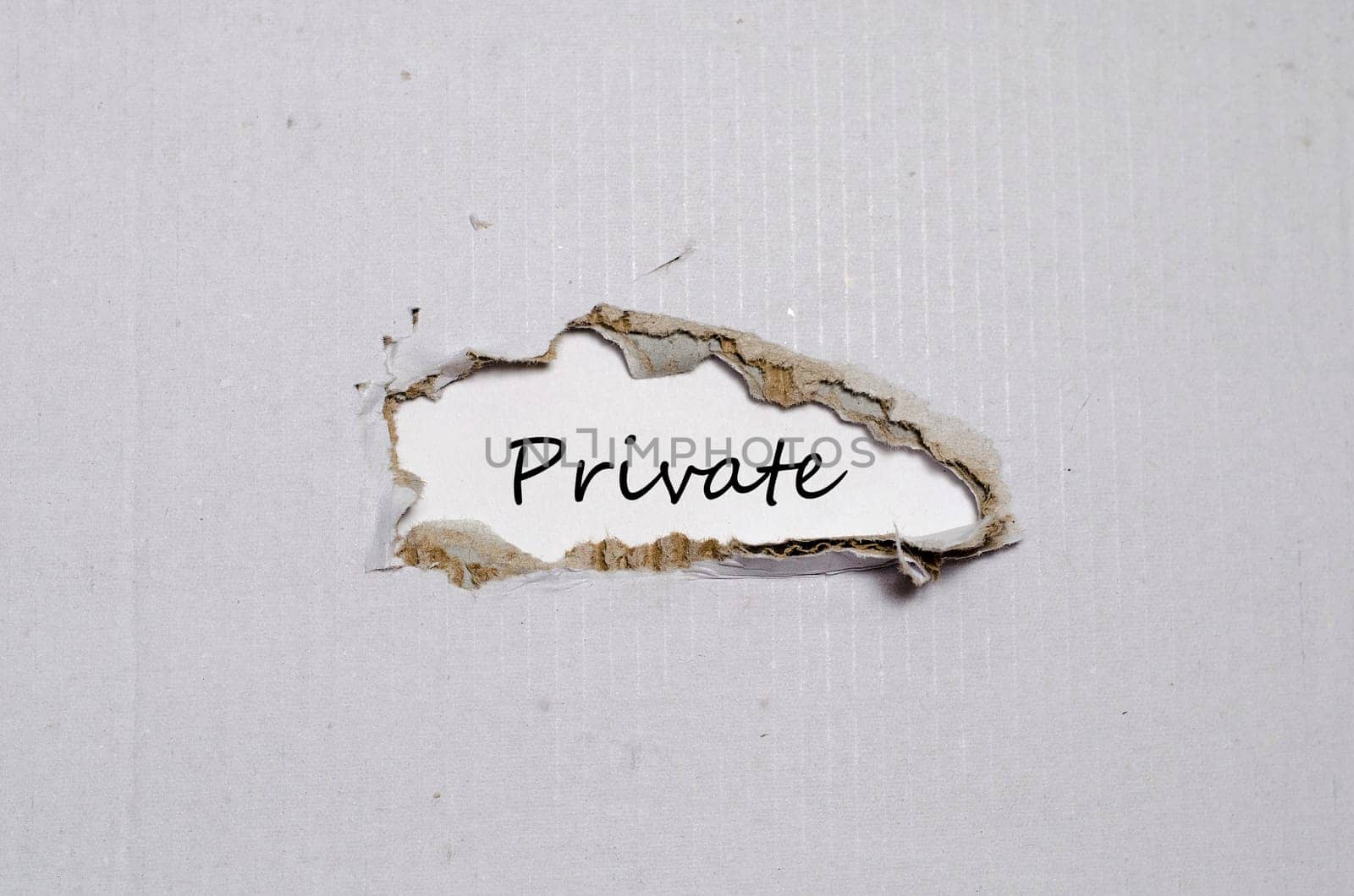 The word private appearing behind torn paper