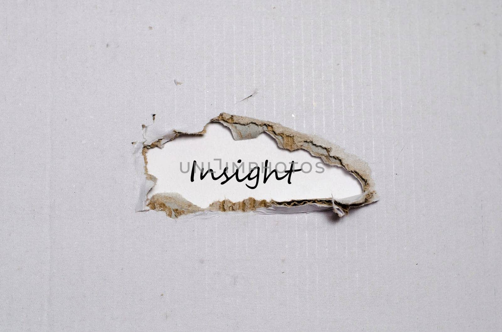 The word insight appearing behind torn paper