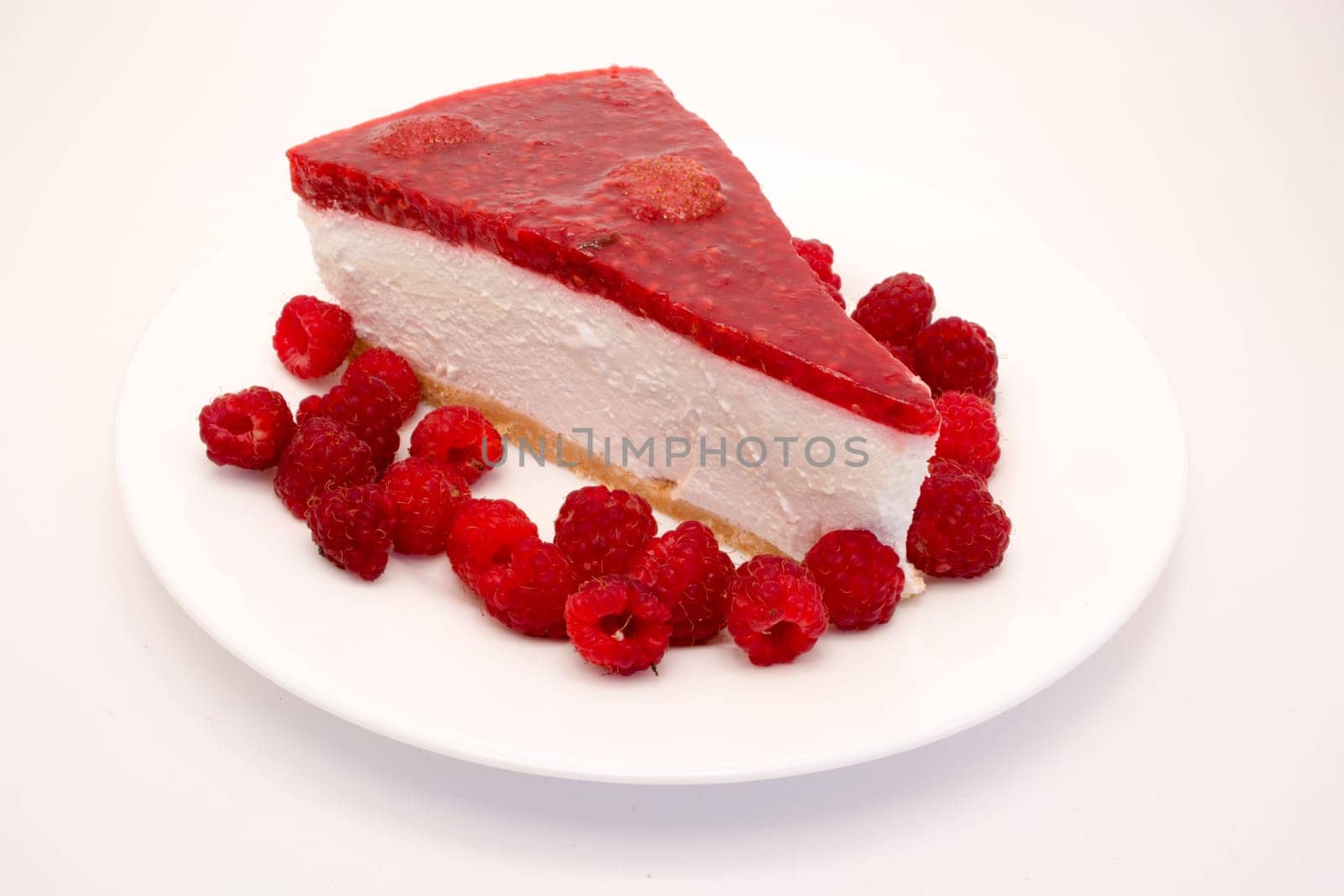 Cheesecake slice with raspberries on a white plate isolated on a white background