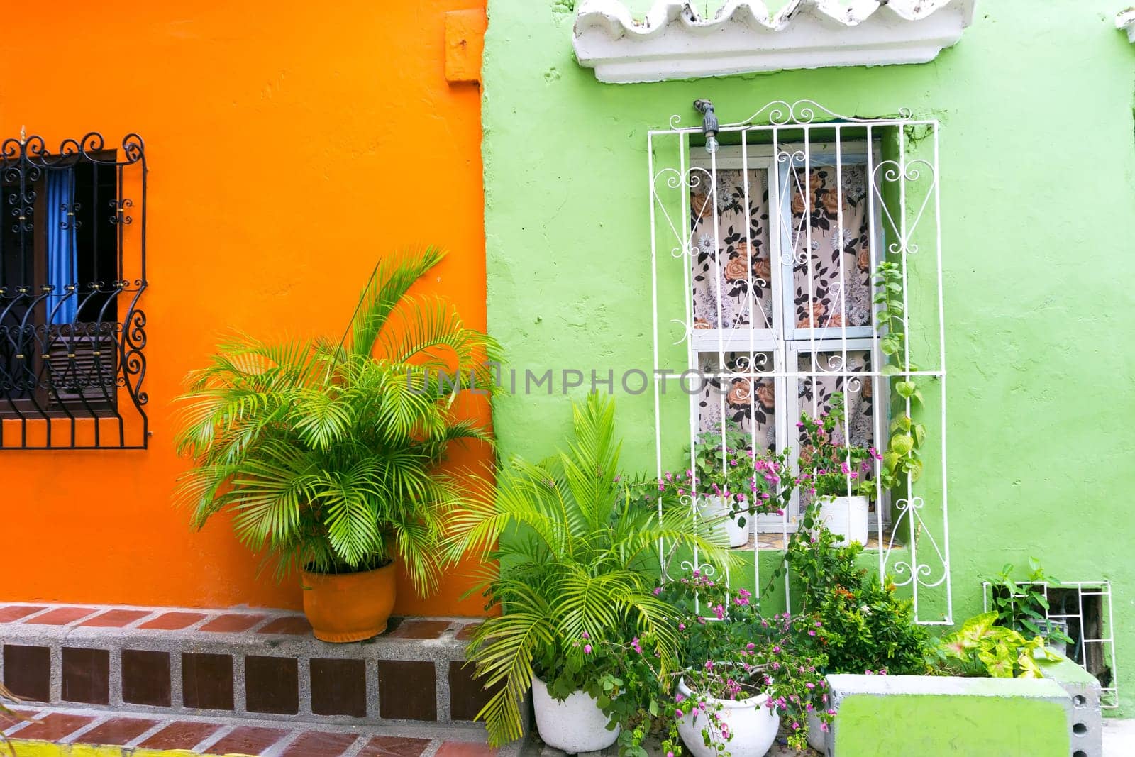 Beautiful green and orange colonial architecture with lush green plants in Cartagena, Colombia