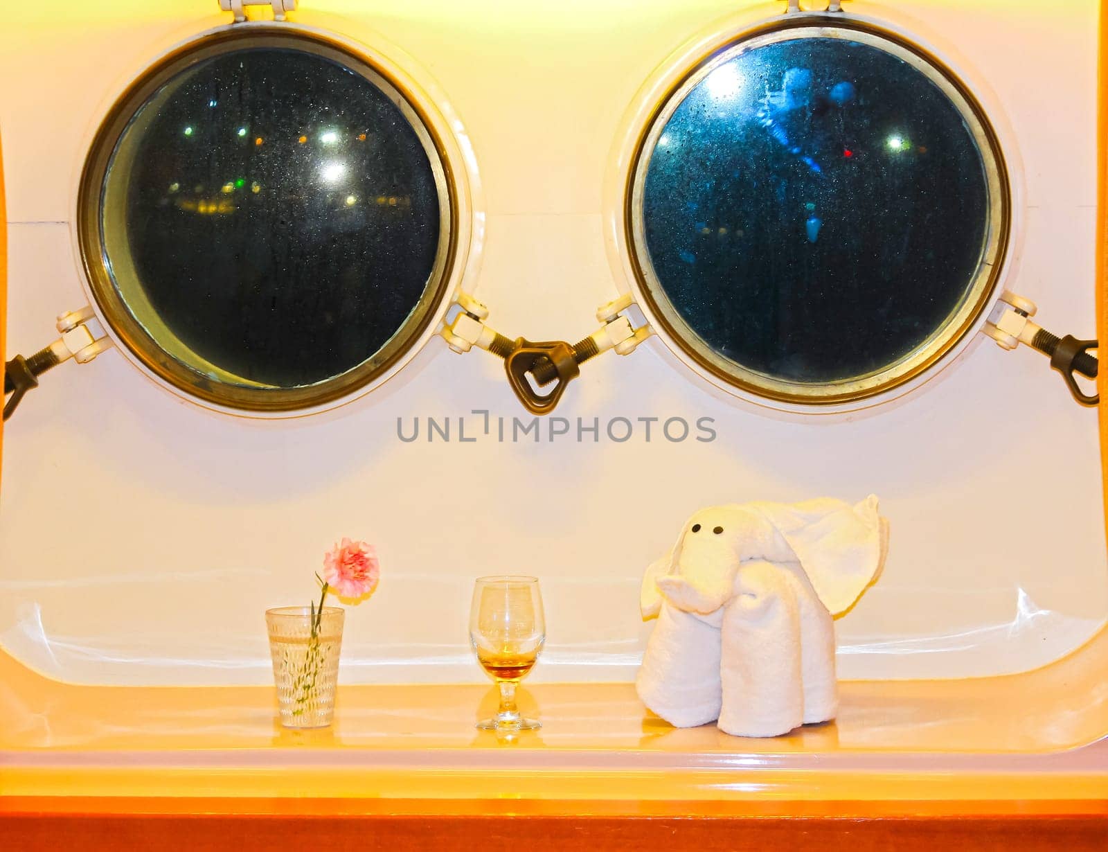 The figure of the towel against two windows in the cabin of a cruise ship