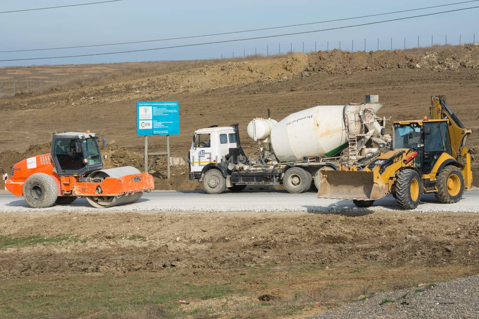 Taman, Russia - March 8, 2016: Ice Rink, cement mixer and excavator are on the road leading to the bridge being built Kerch