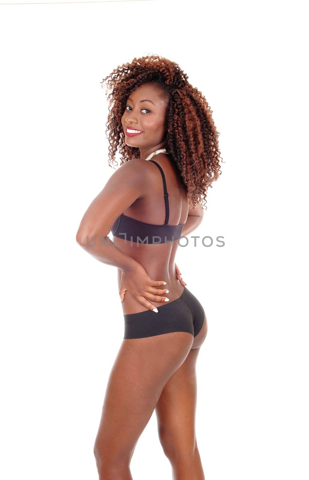 A few of the back a young African American woman standing.in black panties and bra, isolated for white background..
