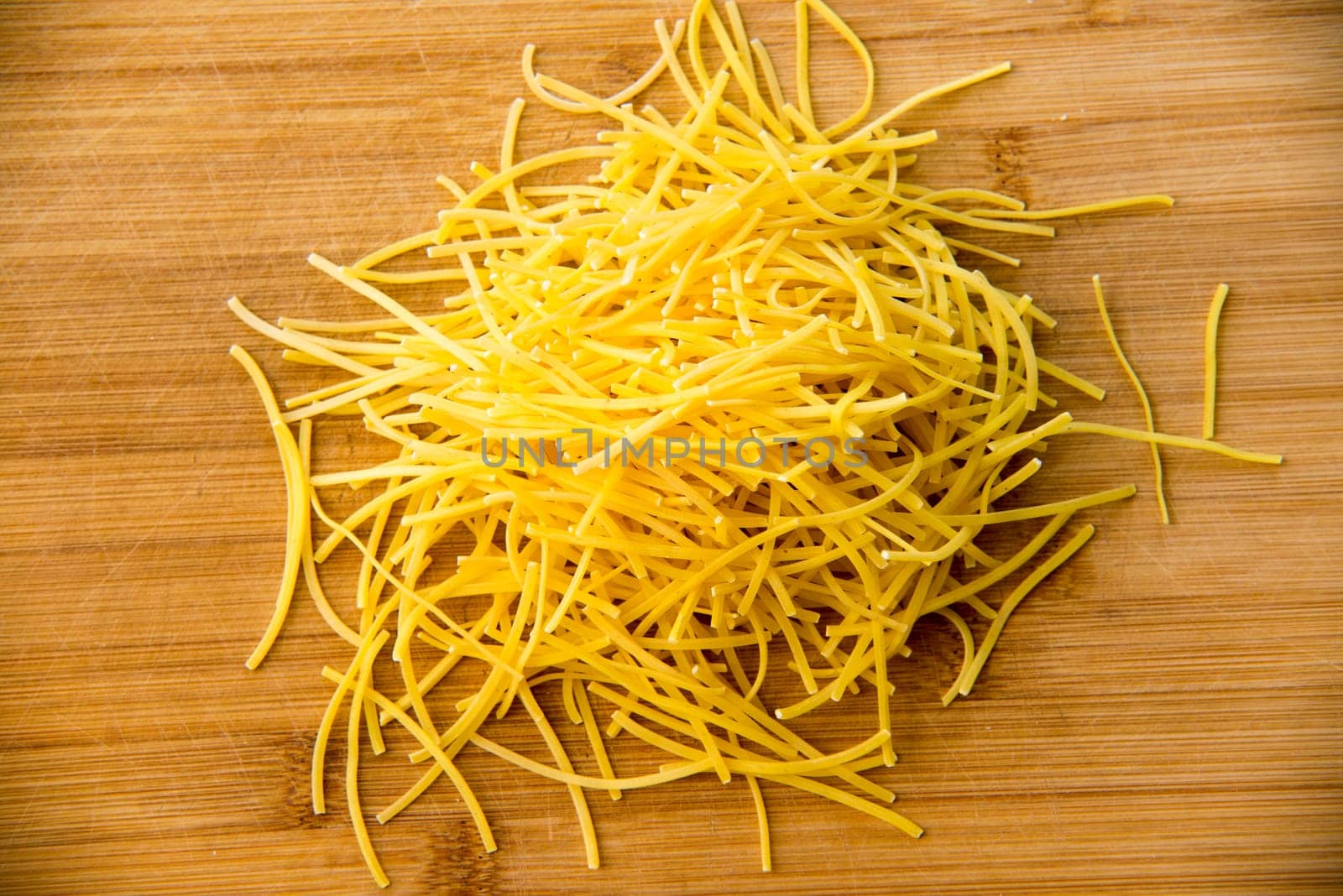 small dry pasta noodles on wood background