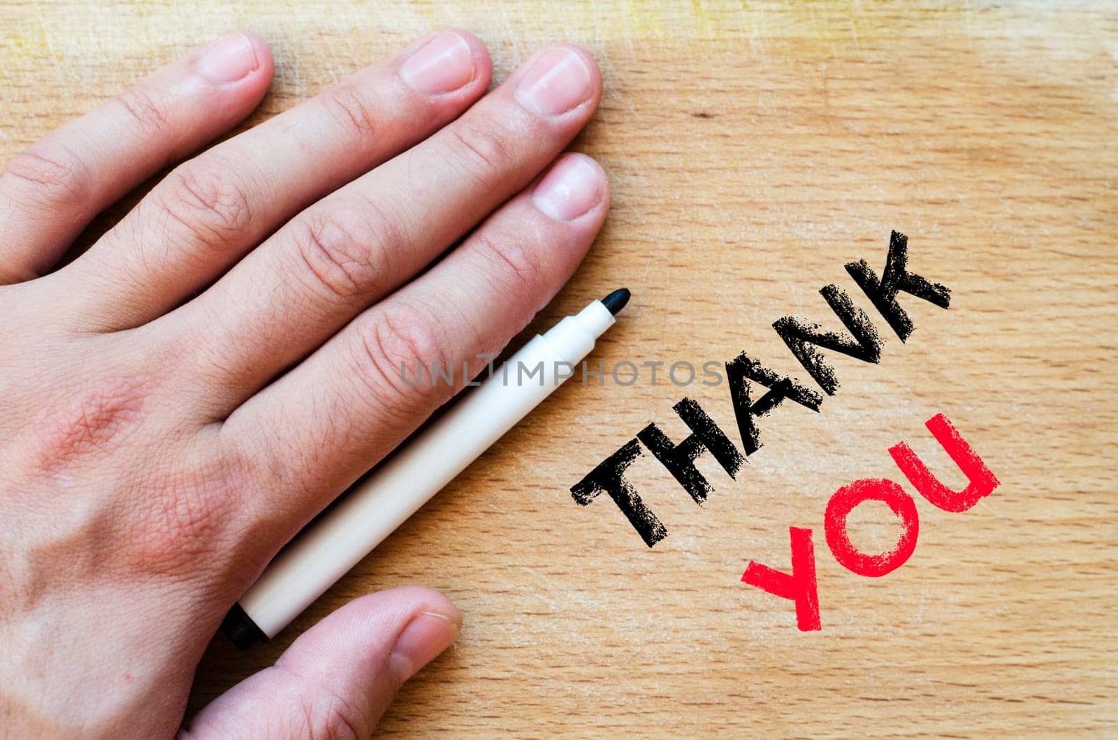 Human hand over wooden background and thank you text concept