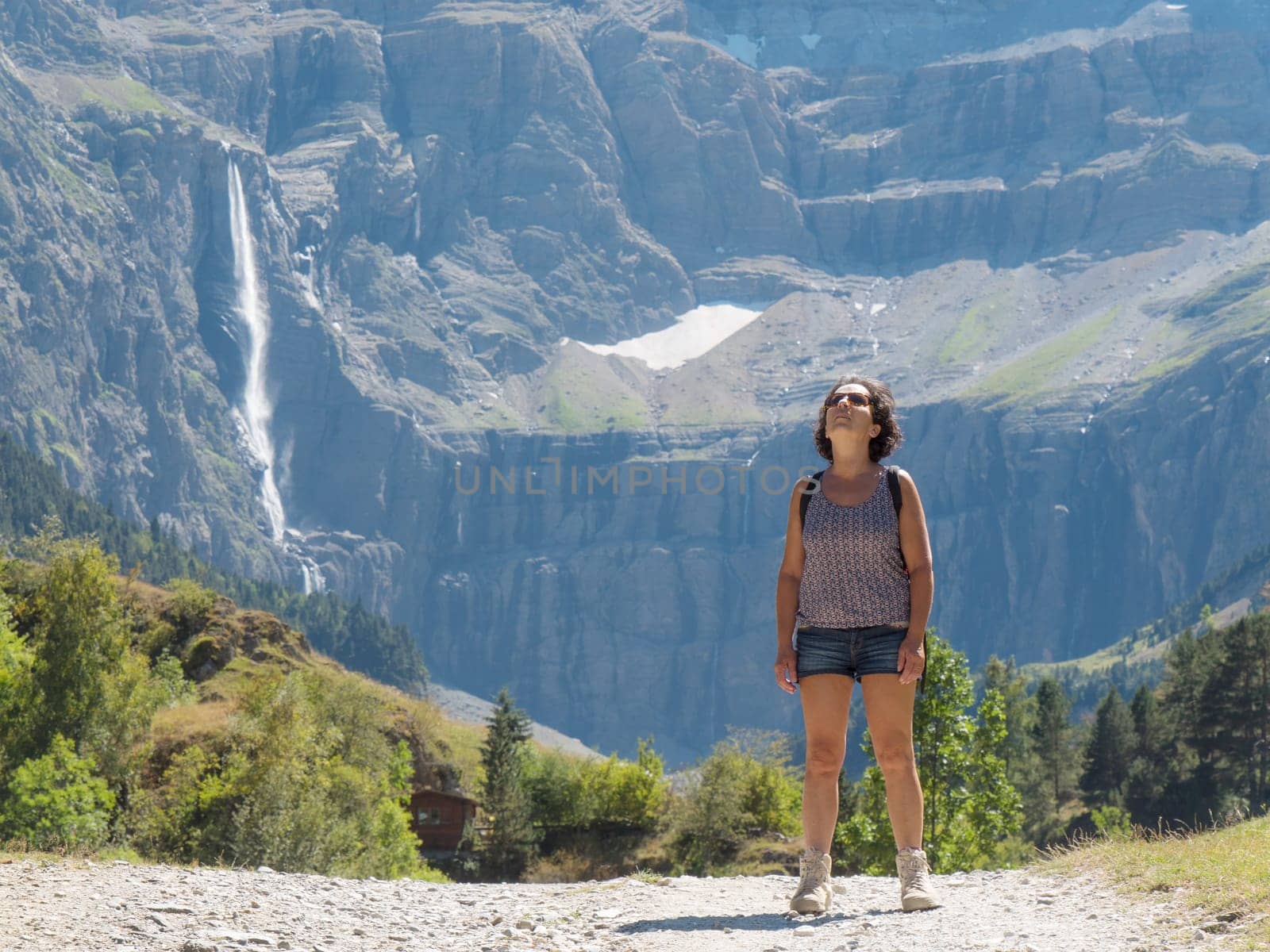 A woman hiker and cirque de Gavarnie in the French pyrenees mountains