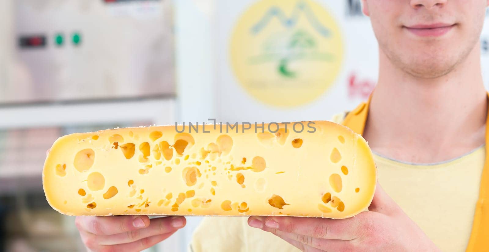 Alpine cheese for sale offered by a salesman.