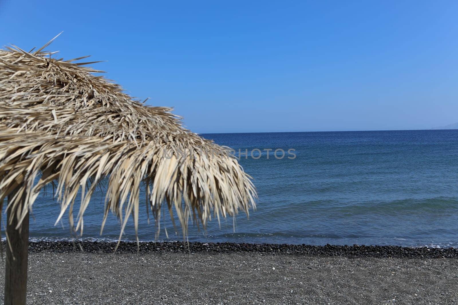 The Kamari beach with black volcanic stones at Santorini island, Greece