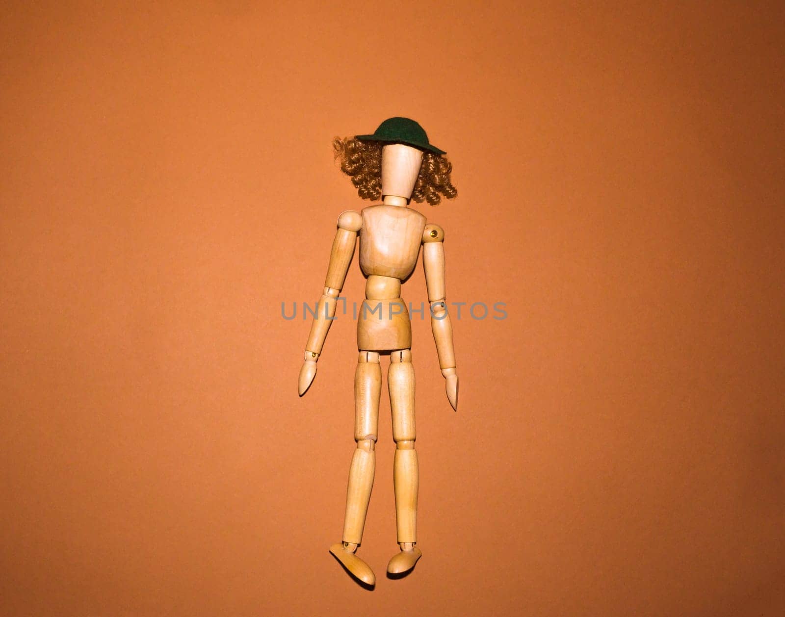 The wooden woman with hat and hair on brown background