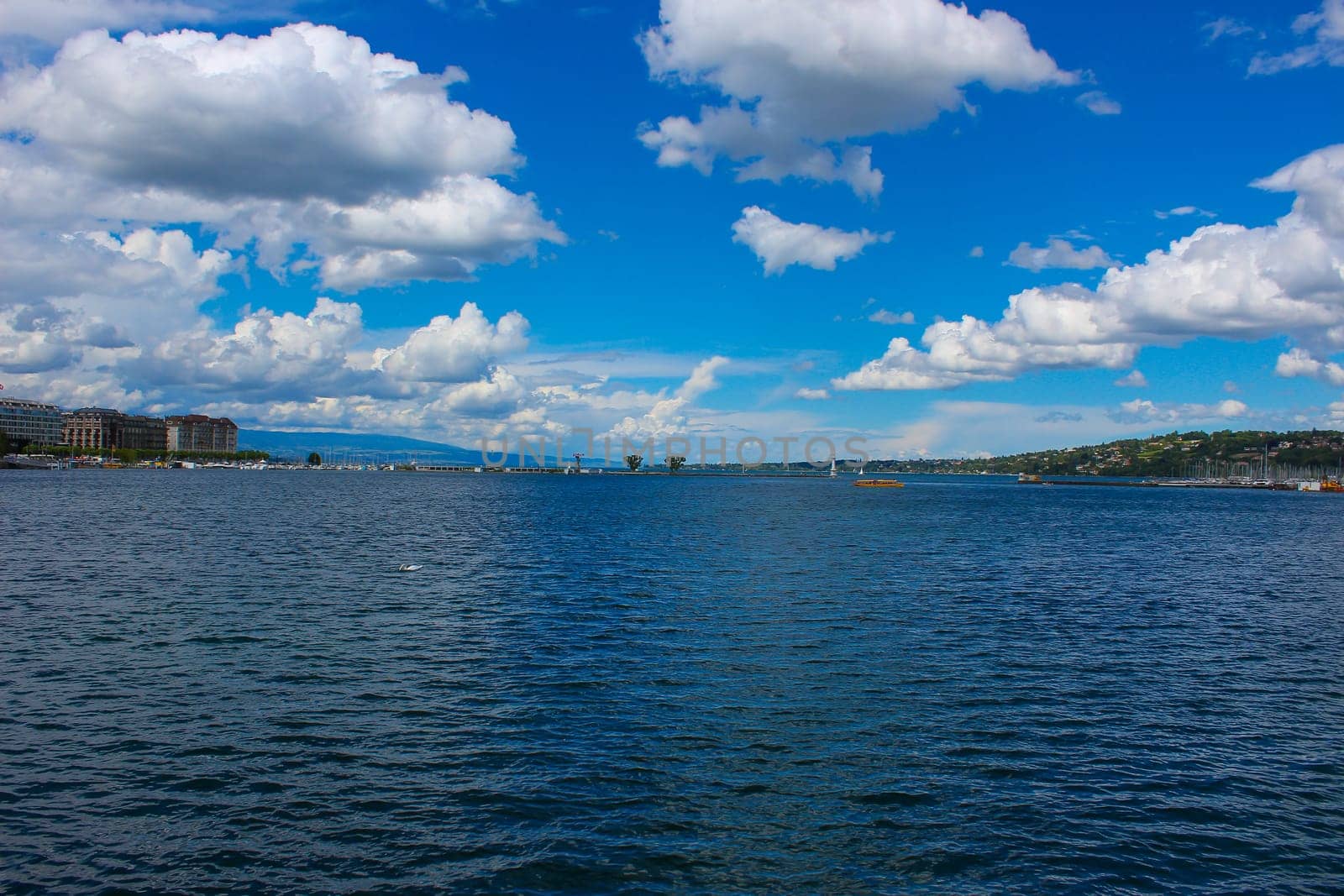 Lake Geneva. Panoramic view of harbor district with blue sky and clouds in summer, Canton of Geneva, Switzerland