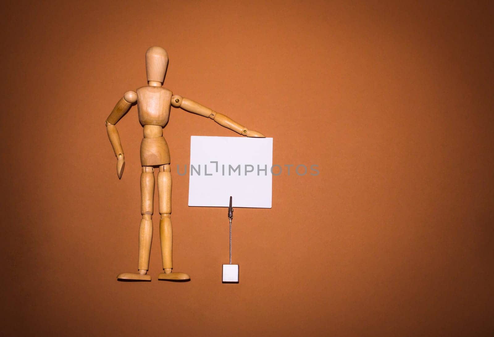 The wooden man with hands up to hold up your banner on brown background