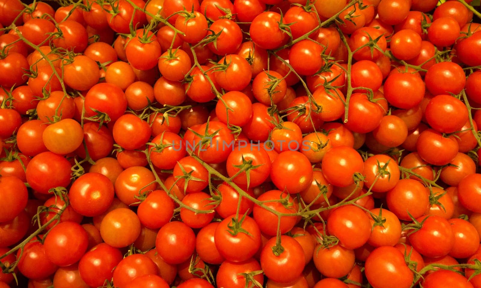 many small cherry tomatoes in the market ready to sell