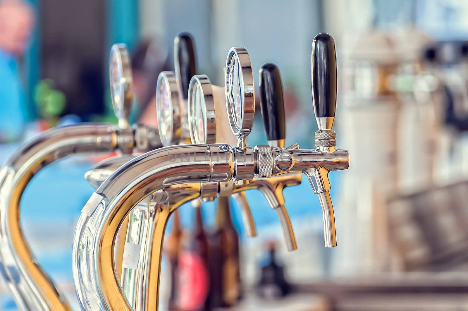 Draught beer taps and other beverages in a bar.