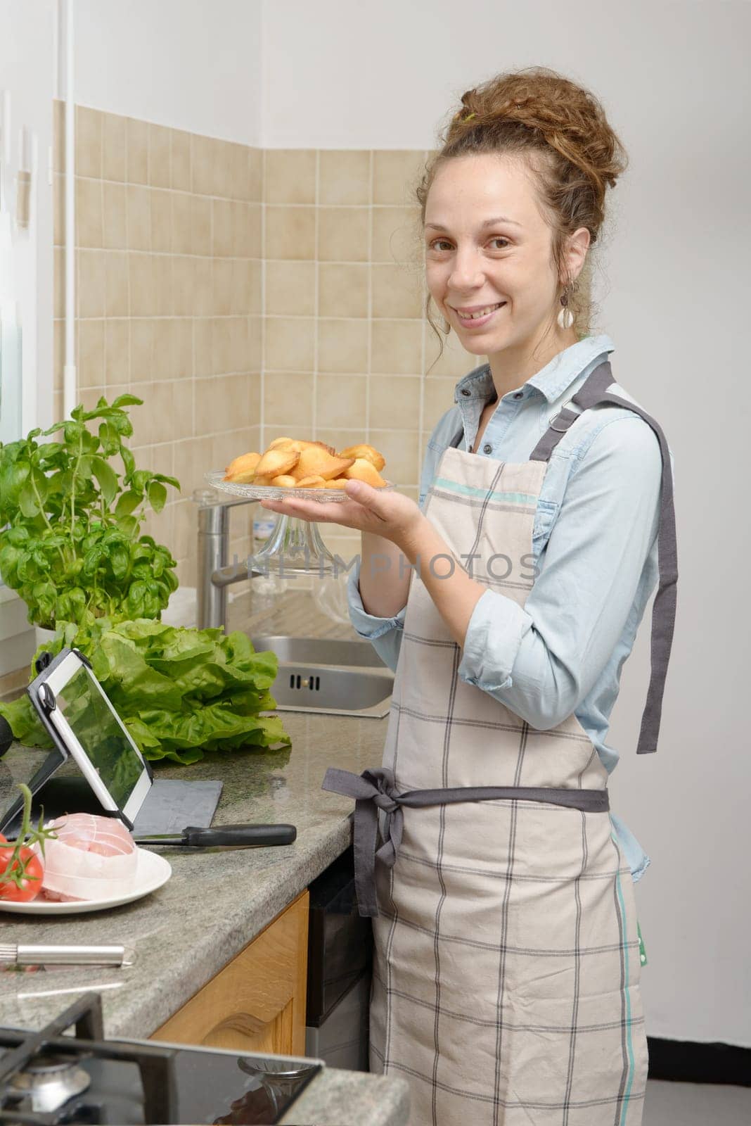 a young woman with madeleine cookies in the kitchen