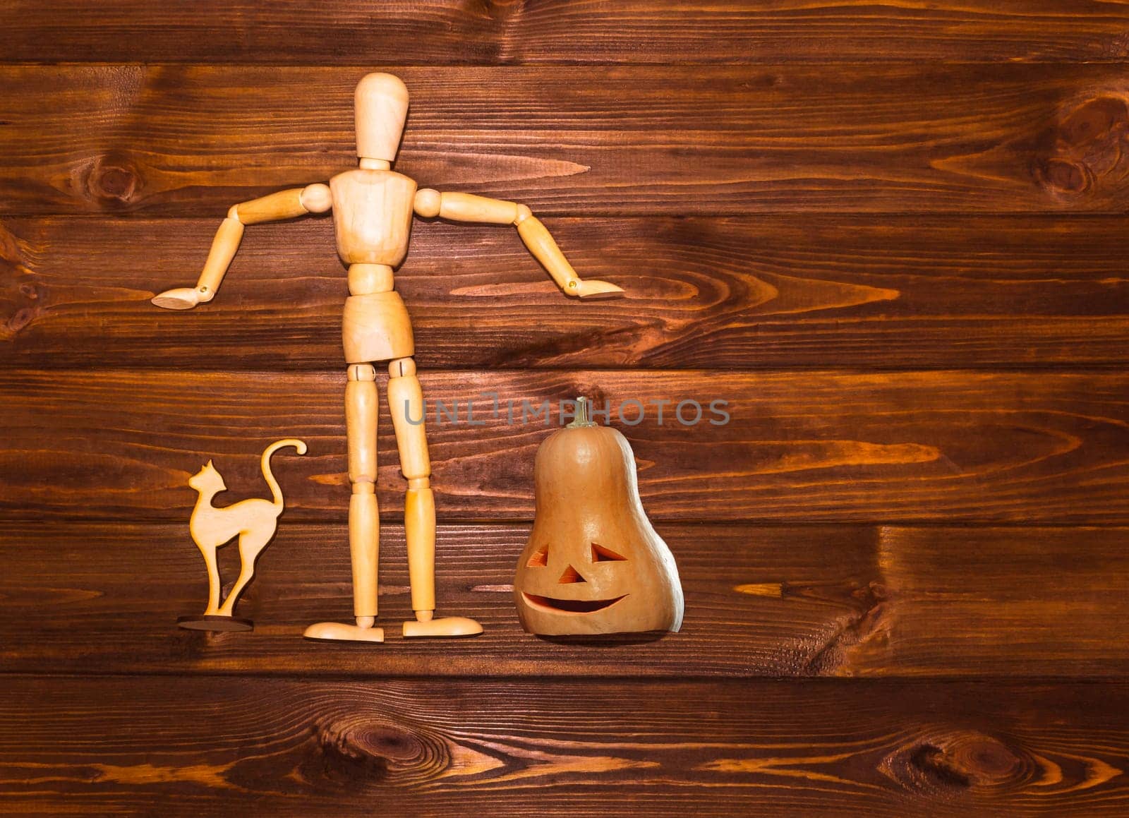 The Halloween concept - wooden man with pumpkin and cat on wooden background