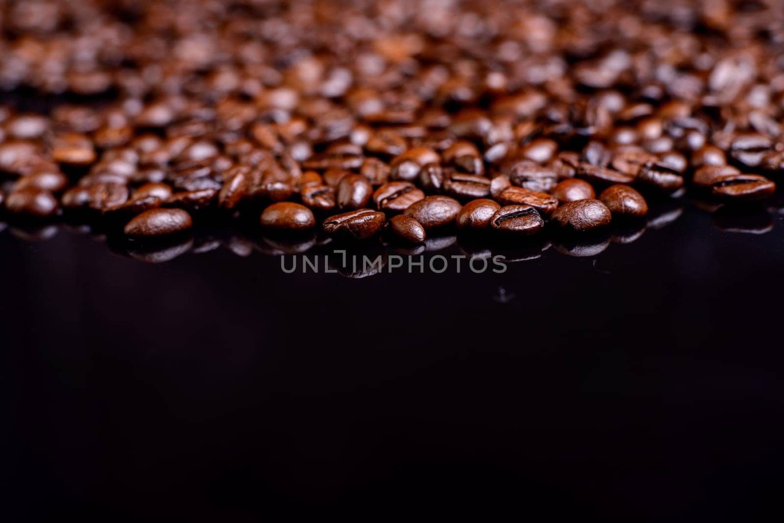 a lot of brown roasted coffee beans on black ground