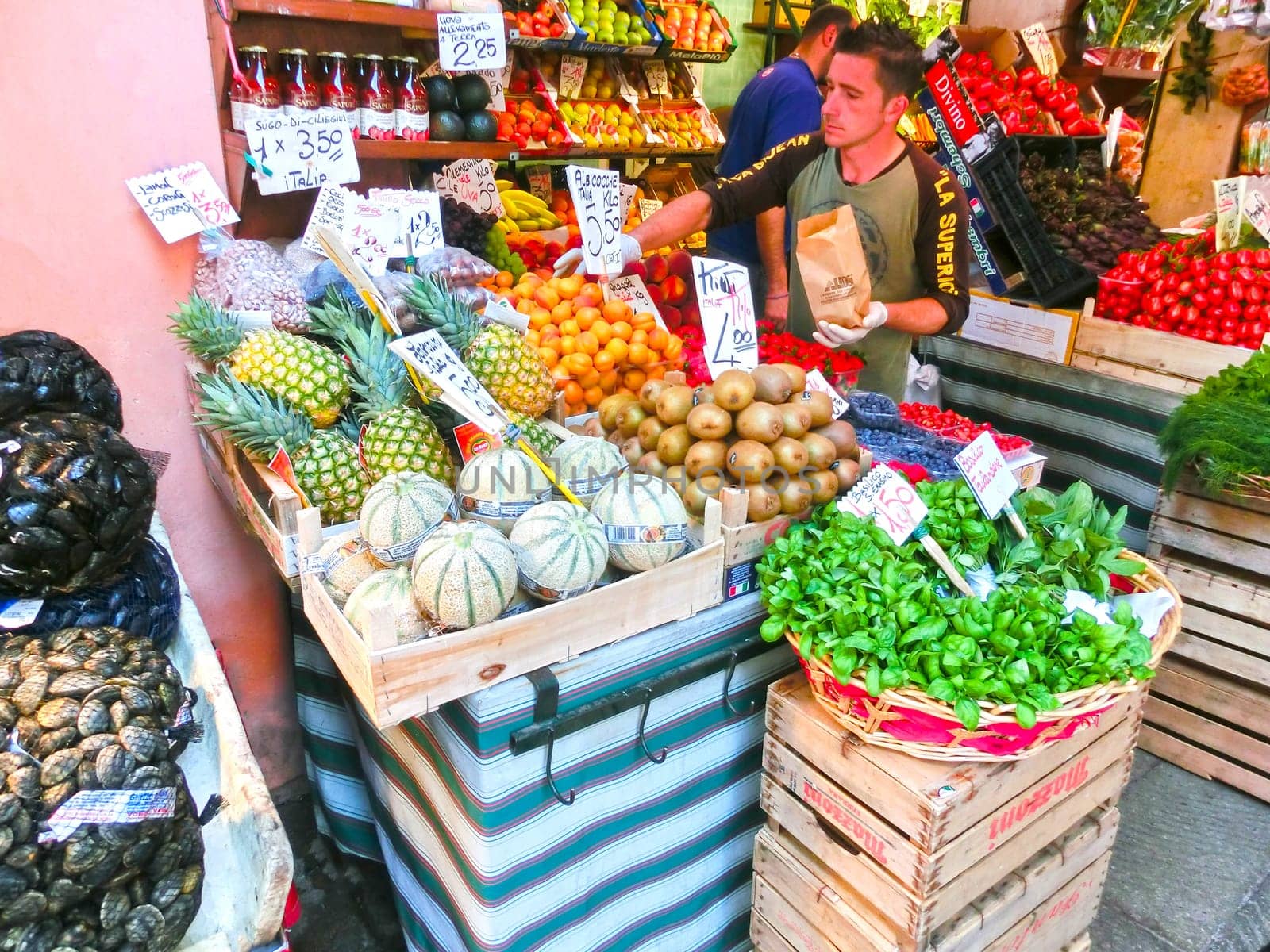 Venice, Italy - May 10, 2014: People near a counter with vegetables on a market in Venice, Italy