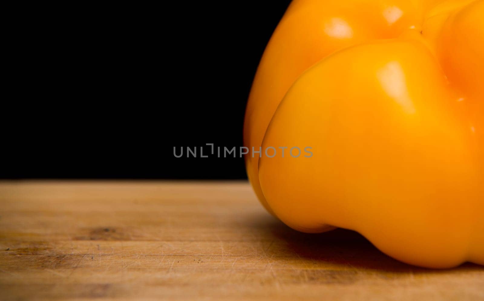 close up on yellow paprika on wood,black background
