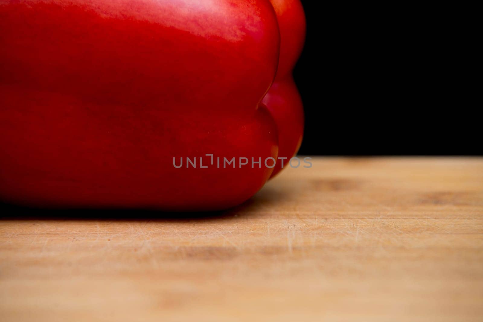 close up on red paprika on wood,black background