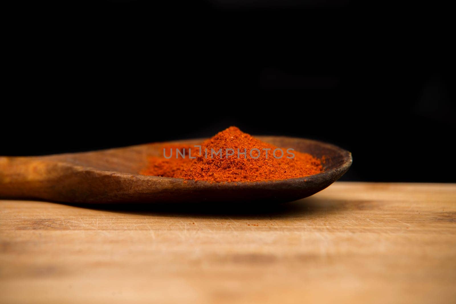 close up on paprika powder in wood bowl
