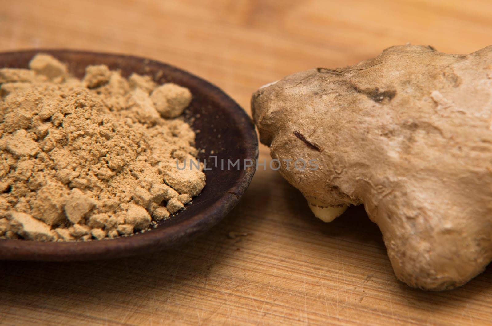close up on fresh ginger and powder on wood
