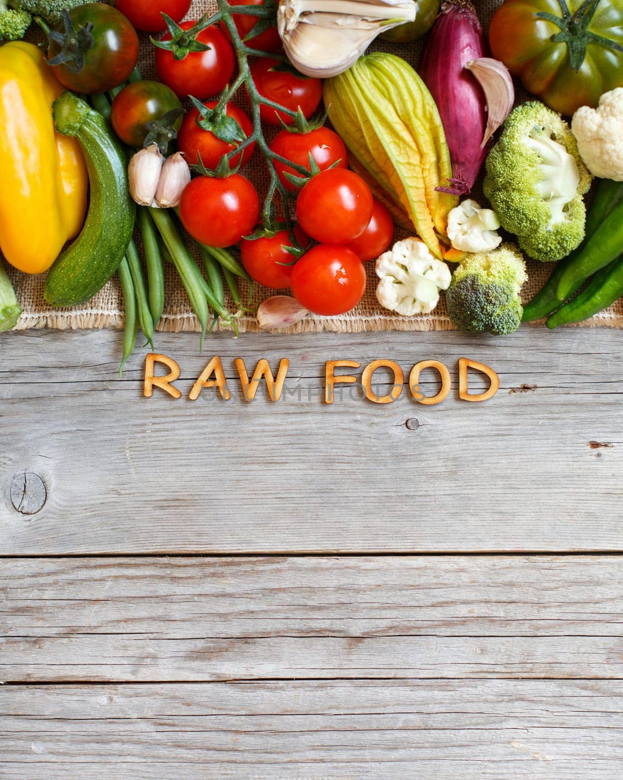 Fresh vegetables and wooden letters on an old wooden table