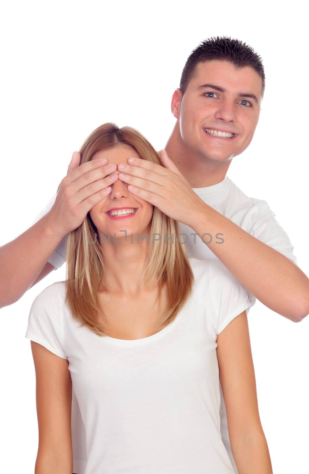 Smiling boy covering his girlfriend's eyes to surprise him isolated on a white background