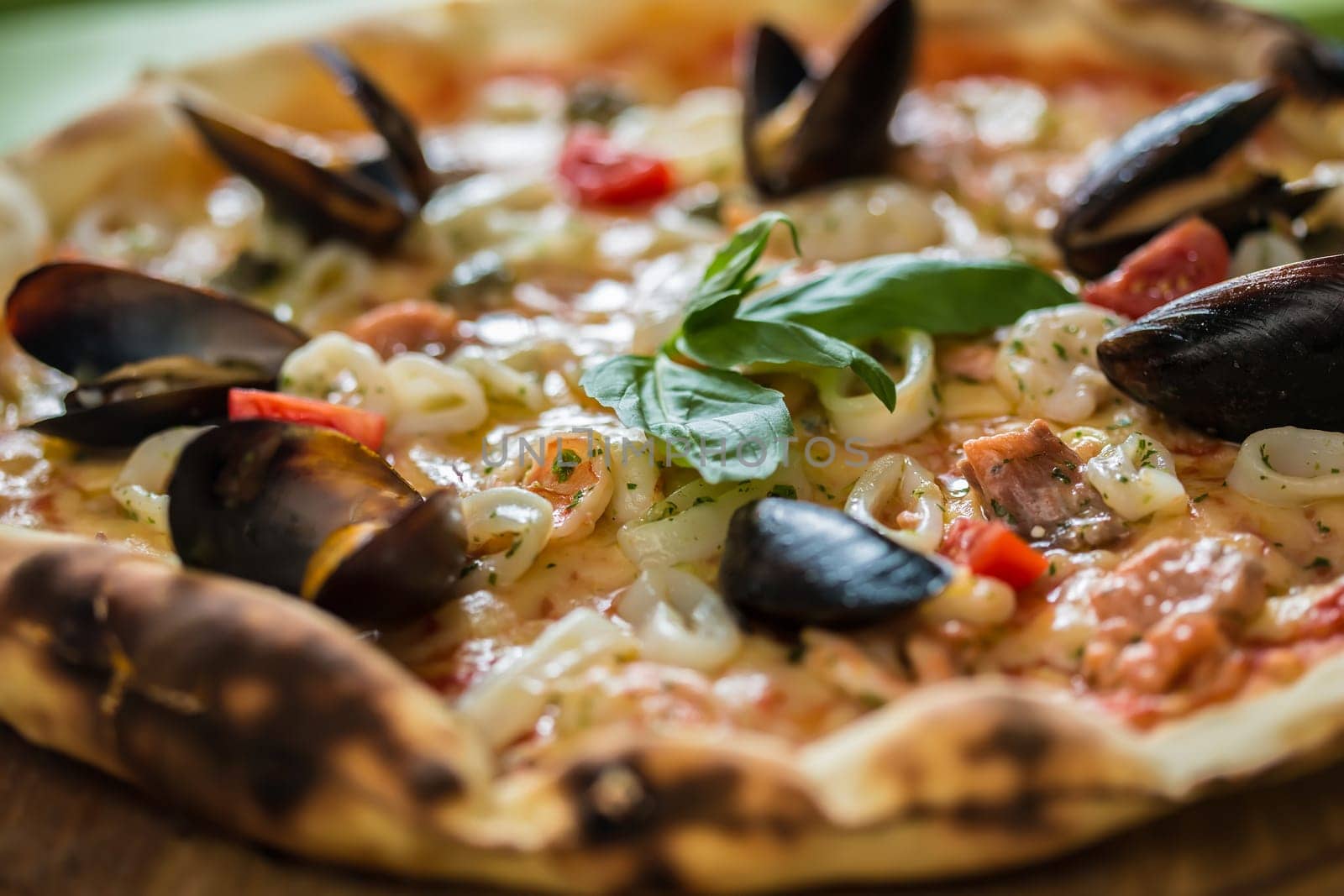 Traditional italian seafood pizza with prawns and mussels. selective focus