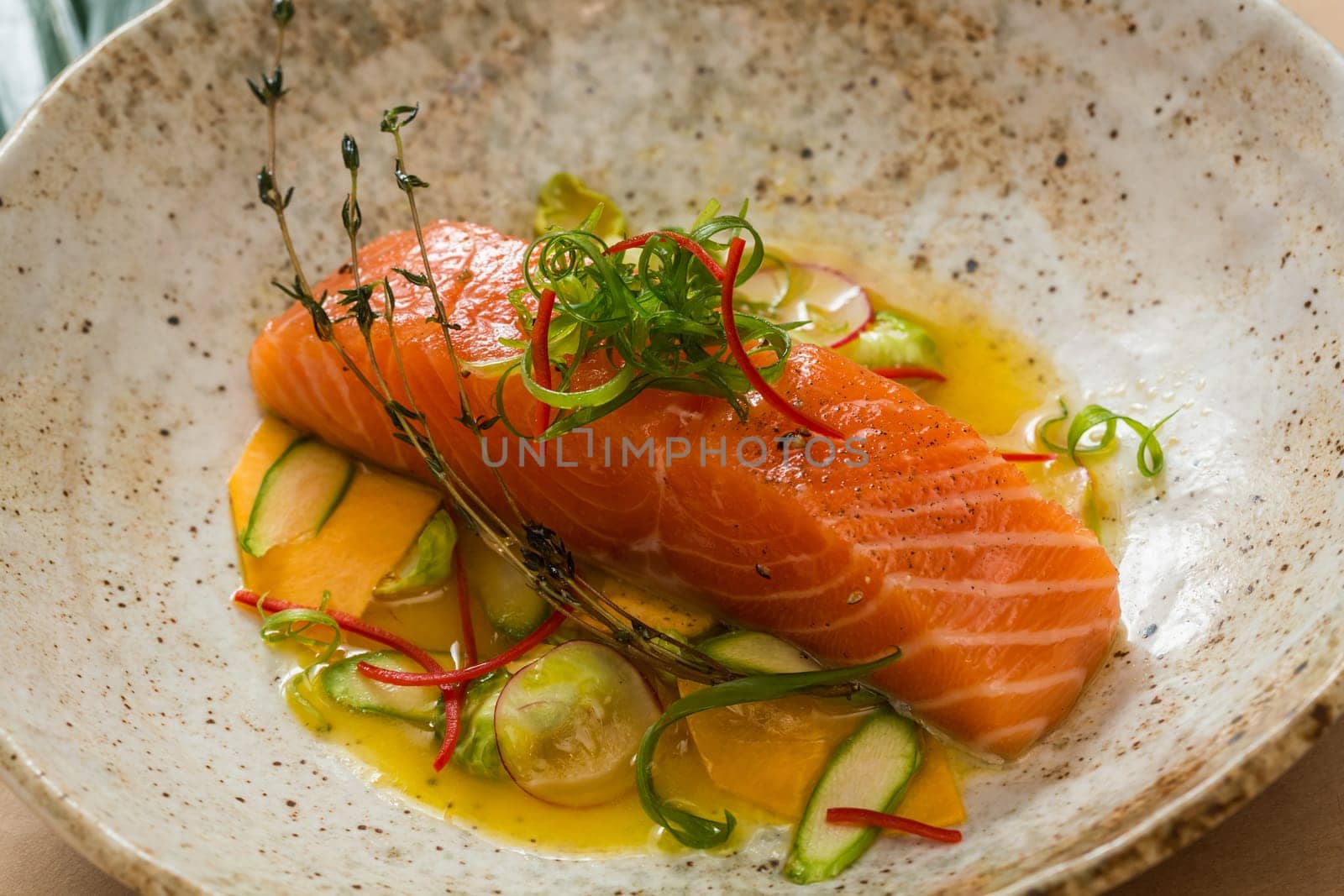 Marinated salmon with green salad and spices.  Shallow dof.
